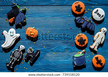 Cook halloween gingerbread cookies with witch, bat. Blue background top view copyspace