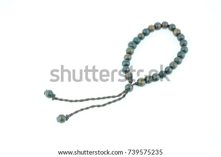 Closeup of wood tasbih or rosary on a white background. Selective focus and copy space.                                Royalty-Free Stock Photo #739575235