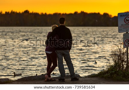 Young couple at a lake watching sunset