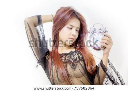Young attractive girl wear black night dress press button snooze wake up on vintage alarm clock.Adequate sleep and sleep tight concept. image for background, copy space and object.