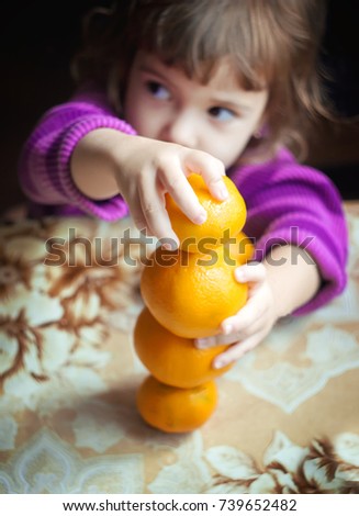 Child and tangerine. Selective focus. 