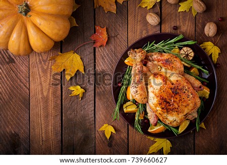 Roasted turkey garnished with cranberries on a rustic style table decorated with pumpkins, orange, apples and autumn leaf. Thanksgiving Day. Flat lay. Top view
