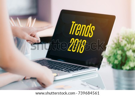 trends 2018 on laptop screen with business people meeting in front of computer screen on desk at office,Digital marketing concept