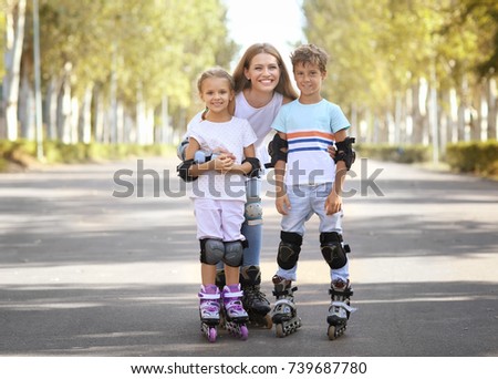 Mother with son and daughter rollerskating in park