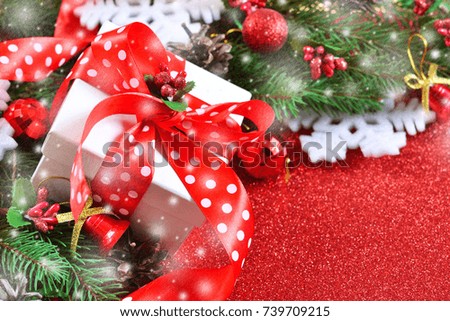 Happy New Year and Merry Christmas. New Year red background with spruce and decorations of balls and snowflakes. Snow in the photo.
