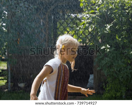 little girl in the rain watching in front of her