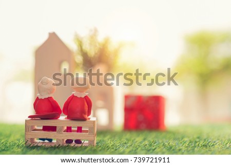 Doll senior couple Sit down on green grass at home