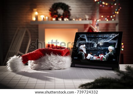 tablet in xmas interior and santa claus with elf 