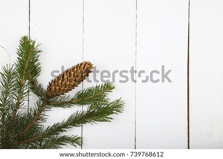 Fir branches with cones on a white wooden background. Ornaments for Christmas or New Year. Border.