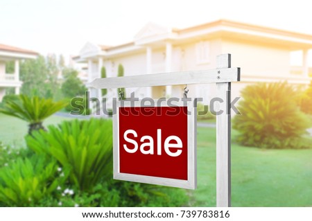 Signboard with word SALE in front of house