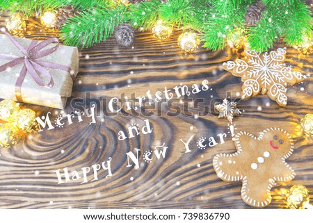 Christmas fir tree with homemade gingerbread cookies, gift and lights on old wooden background with space for text. Merry Christmas and Happy New Year. Xmas concept. Top view. Copy space.