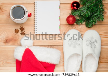 branch of a Christmas tree, balls and notebook on wooden boards top view