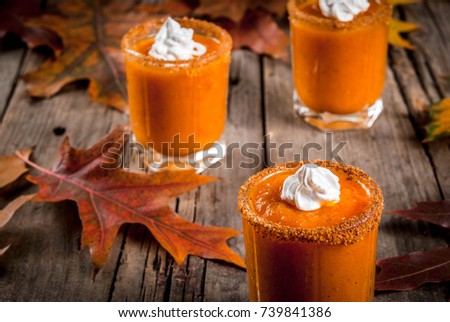 Autumn drink. Ideas and recipes for Thanksgivings, Halloween. Alcohol cocktail Pumpkin Pie Vodka Shots on old rustic wooden table with fall leaves, copy space