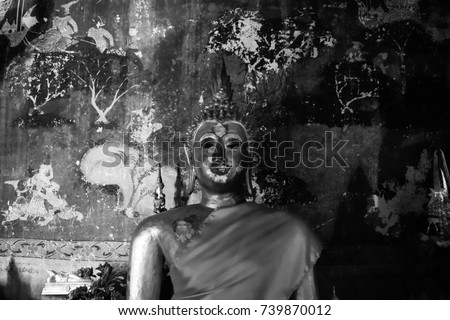 Black and white Buddha statue with Thai wall painting