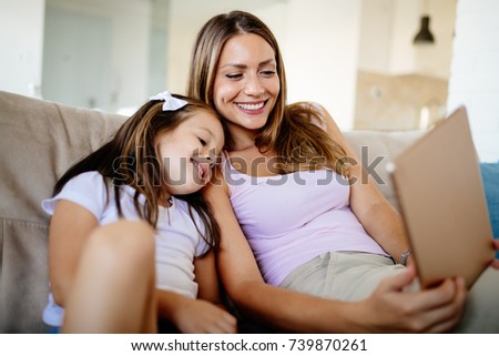 Happy mother with her daughter using digital tablet