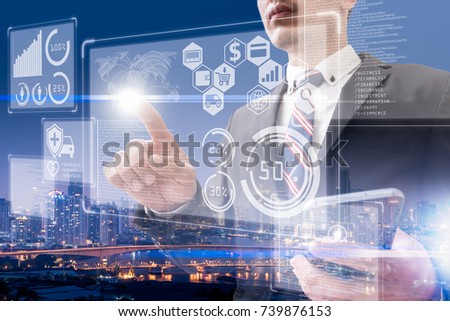The abstract double exposure image of the business man point to the hologram and cityscape is backdrop. The concept of cashless society, online payment, financial and internet of things.