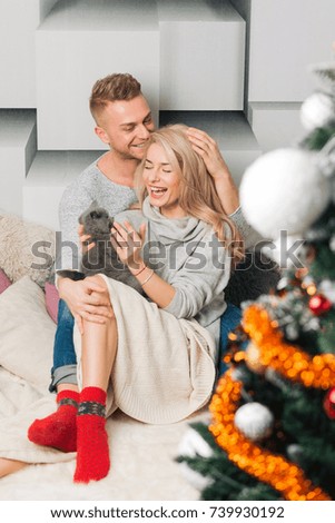 Happy cozy couple inside enjoying a good time around Christmas time