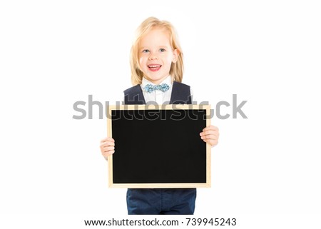 Smart happy child in suit is holding blank blackboard and smiling isolated at white background.
