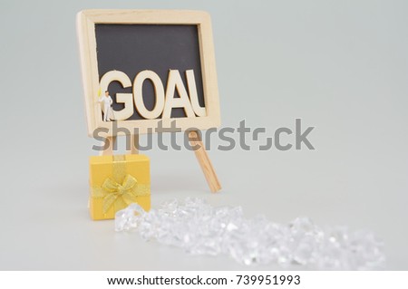 Man effort to work hard hold flag and golf club for successful in goal. Man is walking from left to right of blackboard and jumping to gold gift box time lapse. Business success concept photography.