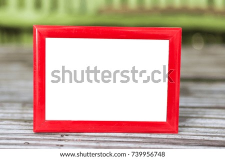Red wood frame on wooden desk.