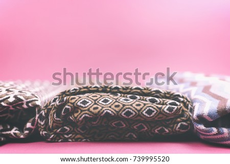 Warm and fashionable women's denim clothing folded on a colored background.