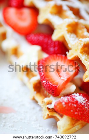 Strawberries and cream cheese between two waffle halves close up