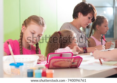 classes in a creative children's school, posing girls, boys and a teacher