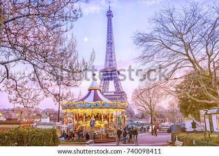 The Eiffel Tower and vintage carousel on a winter evening in Paris, France.