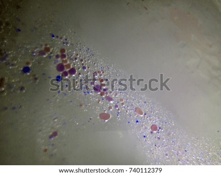 Watercolor paint dissolves in Water droplets on the glass, backlighting from different directions, large magnification, bokeh, Colored abstractions