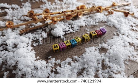 Text Merry x mas on plastic cube with snow decorate on wood plate , christmas theme.