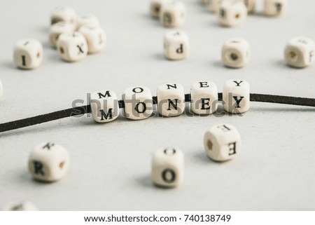 Word Money made of wooden beads on leather lace. A series of minimalistic conceptual compositions of beads. Words, phrases and expressions. Horizontal 