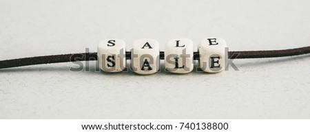 beads with the word Sale on gray background. a series of minimalistic conceptual compositions of beads. Words, phrases and expressions. Long horizontal format