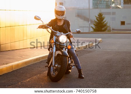 girl in white helmet sits on sportbike Royalty-Free Stock Photo #740150758