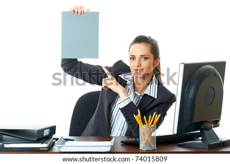 attractive young female office worker holds empty grey card in front of her, point to it with her finger, isolated on white