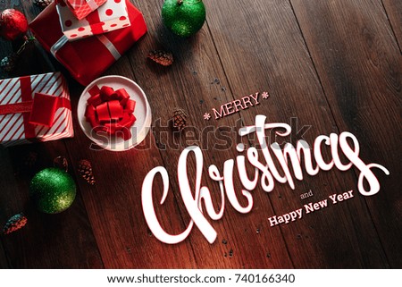 The inscription of Merry Christmas and Happy New Year, decorations and gifts on a wooden brown table. Christmas card, holiday background. Mixed media.