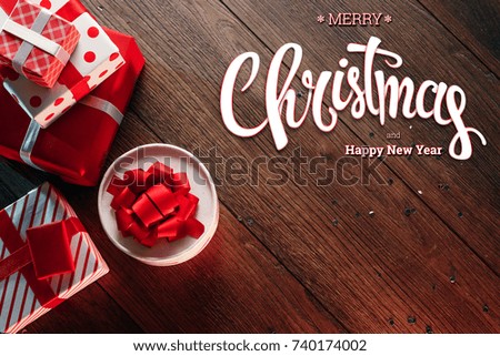 The inscription of Merry Christmas and Happy New Year, decorations and gifts on a wooden brown table. Christmas card, holiday background. Mixed media.