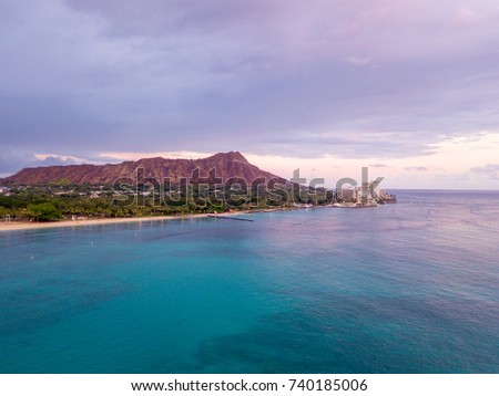 Quite pacific ocean coast by the Waikiki beach with a Diamond head crater on Hawaii islands. Magical purple orange sunset.
