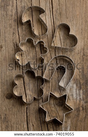 Silver cookie cutters on old wooden table. See series