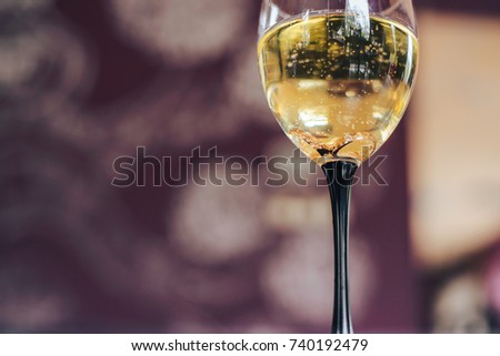 Wedding golden rings in glass of champagne. Symbol of love and marriage. Creative picture with champagne bubbles, glittering in the sunlight.
