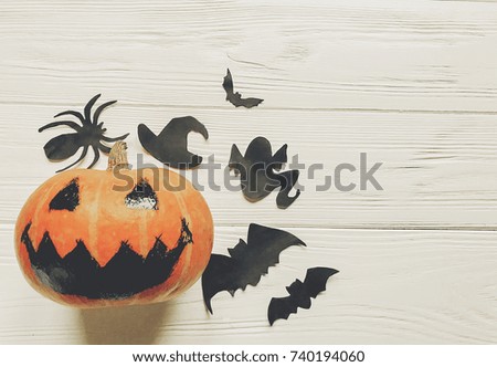 halloween. jack lantern pumpkin with witch ghost bats and spider black decorations on white wooden background top view. seasonal greetings. happy halloween concept, space text