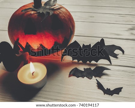 scary halloween. dark spooky jack lantern pumpkin with ghost bats and spider black decorations with candle light on wooden background. holiday celebration. seasonal greetings. happy halloween