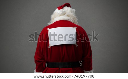 Santa Claus with a blank sign on his back, he is looking down, back view