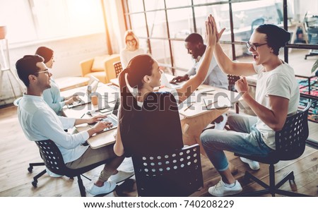 Multiracial young creative people in modern office. Group of young business people are working together with laptop, tablet, smart phone, notebook. Successful hipster team in coworking. Freelancers. Royalty-Free Stock Photo #740208229