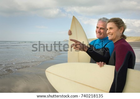 Couple with surfboards on a beach Royalty-Free Stock Photo #740218135