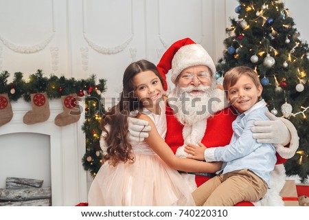 Santa Claus with kids indoors christmas celebration concept Royalty-Free Stock Photo #740220310