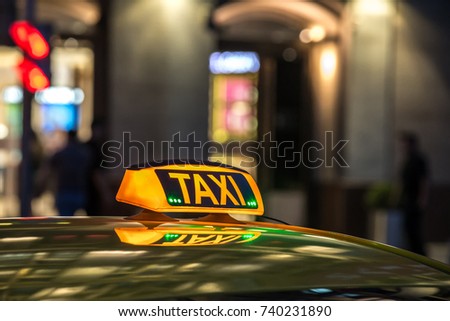 Yellow taxi sign at night in a metropolis. Place for the inscription, the concept of a modern city, comfort, dynamics, speed.