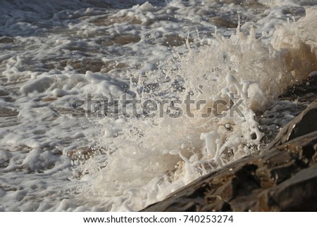 Small wave hits a rock