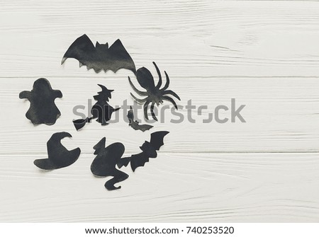 halloween flat lay. happy halloween concept, space for text. witch ghost bats and spider black decorations on wooden background top view. simple cutouts for  holiday celebration. seasonal greetings