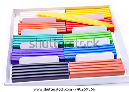 plasticine in a box with a plastic knife on white background