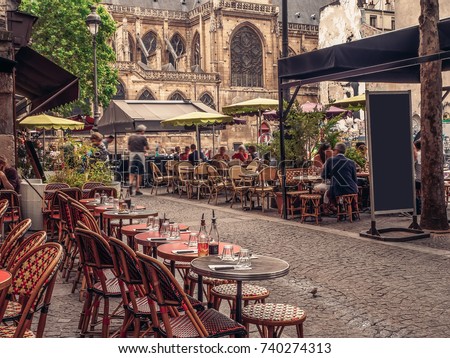 Cozy street with tables of cafe in Paris, France. Architecture and landmarks of Paris. Postcard of Paris Royalty-Free Stock Photo #740274313